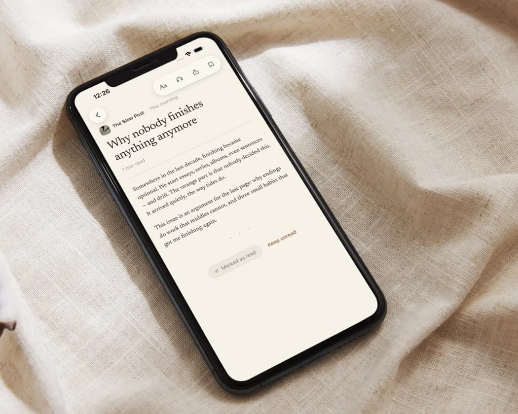 A phone resting on linen, an issue open in the reader